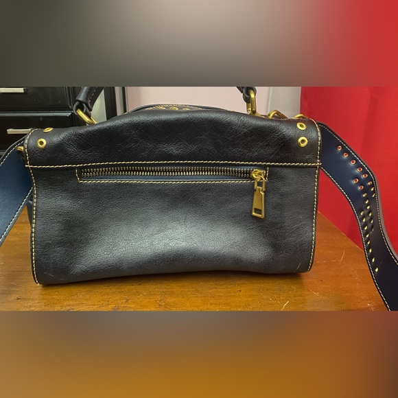 Black leather cross body purse with orange colored medallion on front. - Picture 4 of 14